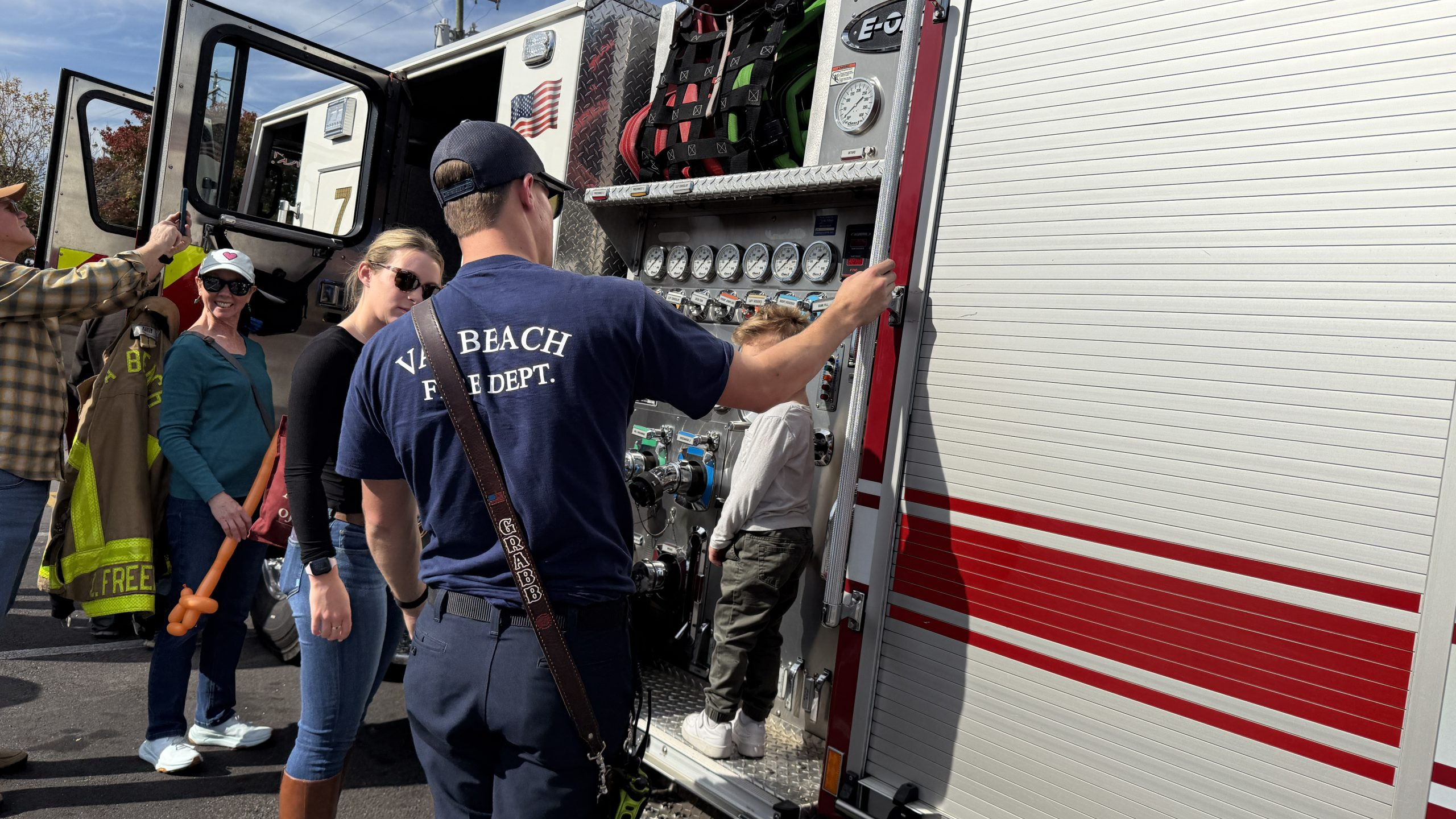firefighter showing mom and young kid the rig at touch a truck town center