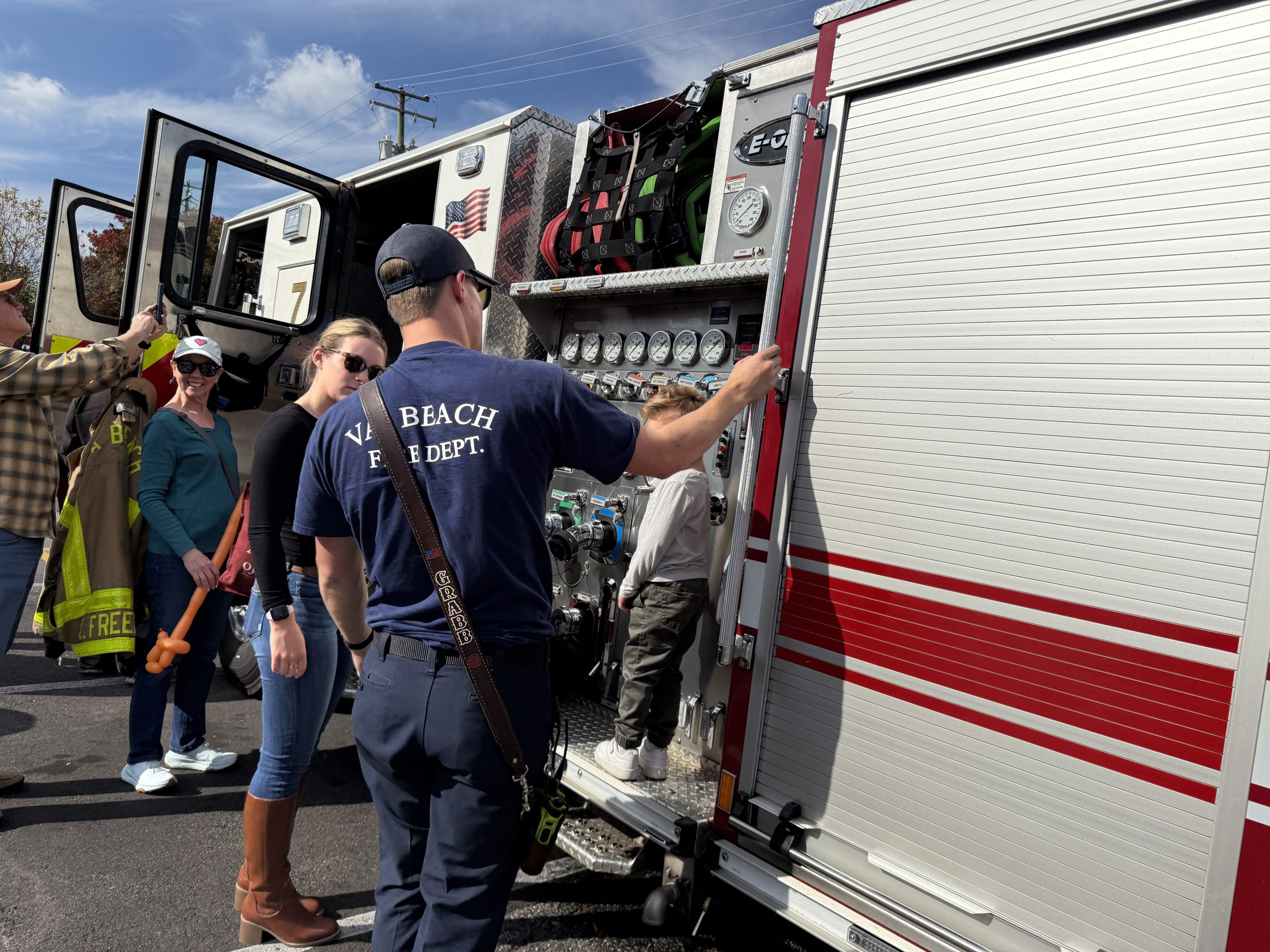 firefighter showing mom and young kid the rig at touch a truck town center